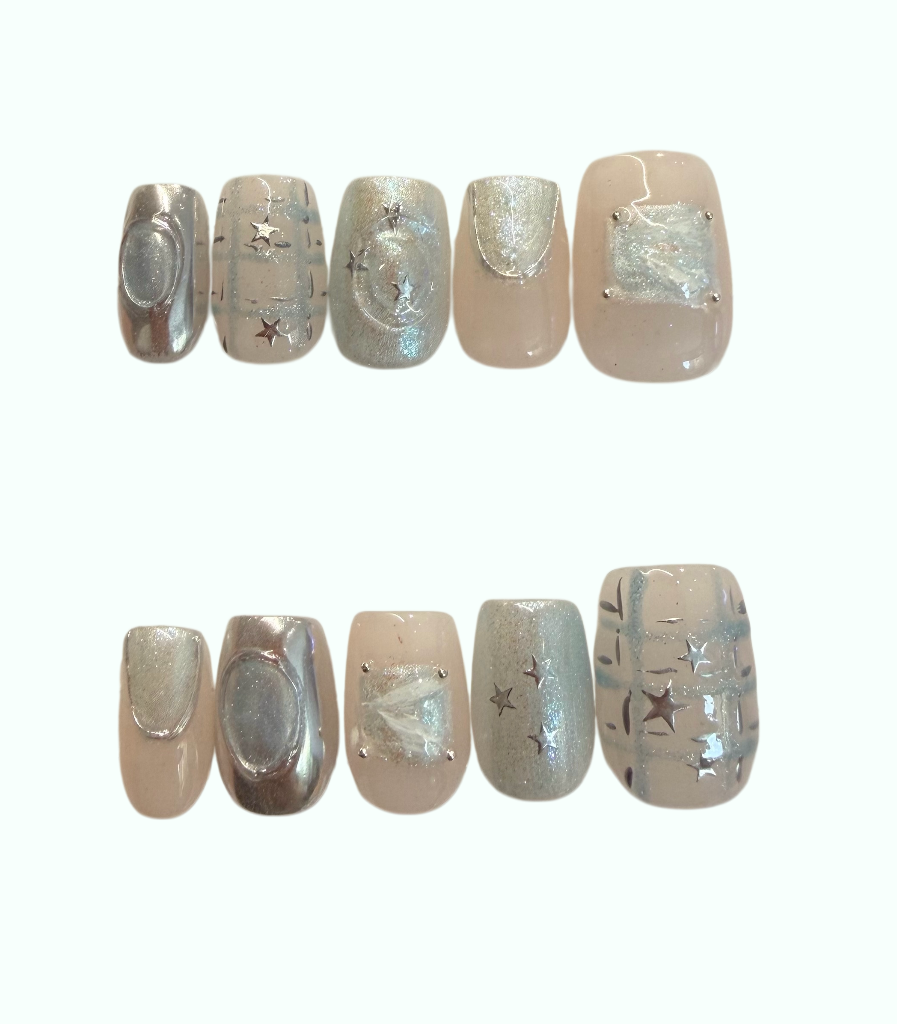 A set of ten press-on nails with a celestial design, featuring silver glitter stars, crescent moons, and envelope motifs on a nude beige base, displayed against a plain white background.