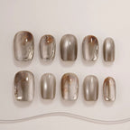 Row of brown and gray gradient nail art designs on a white background