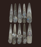 Set of decorative nail tips with gemstone-like embellishments on a dark background