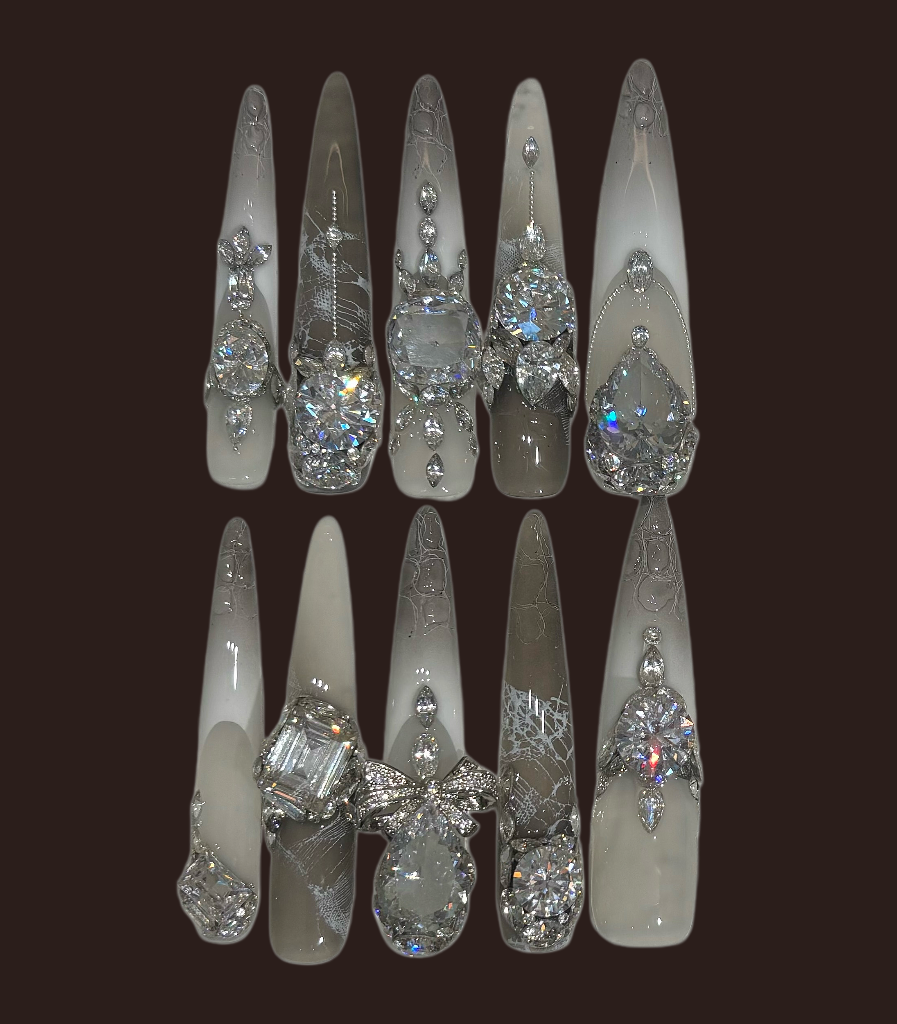 Set of decorative nail tips with gemstone-like embellishments on a dark background