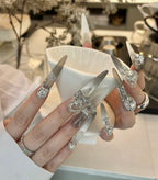 Close-up of hands with decorative nails holding a white cup.