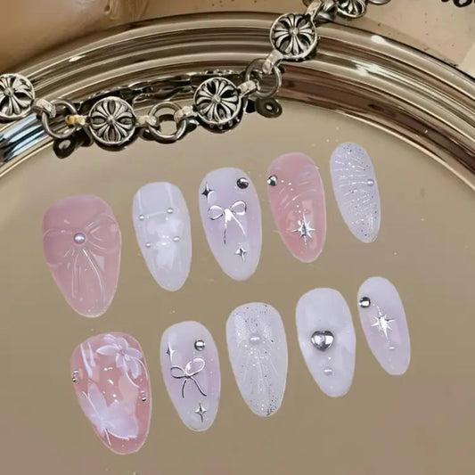 Set of decorative false nails with pink and clear designs on a beige background.