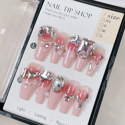 Set of pink nail tips with decorative elements on a 'Nail Tip Shop' packaging.