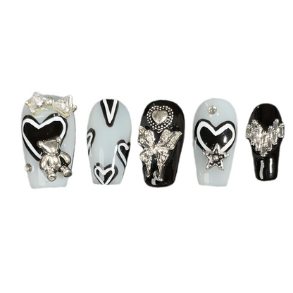 Set of decorative nail art designs with various embellishments on a white background