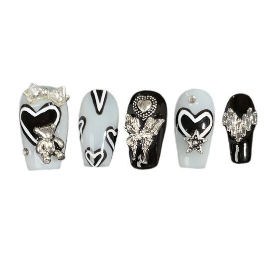Set of decorative nail art designs with various embellishments on a white background