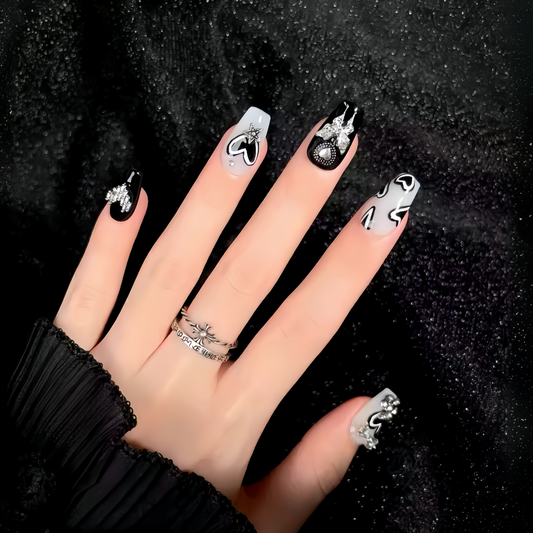 Hand with intricately designed nails against a black background