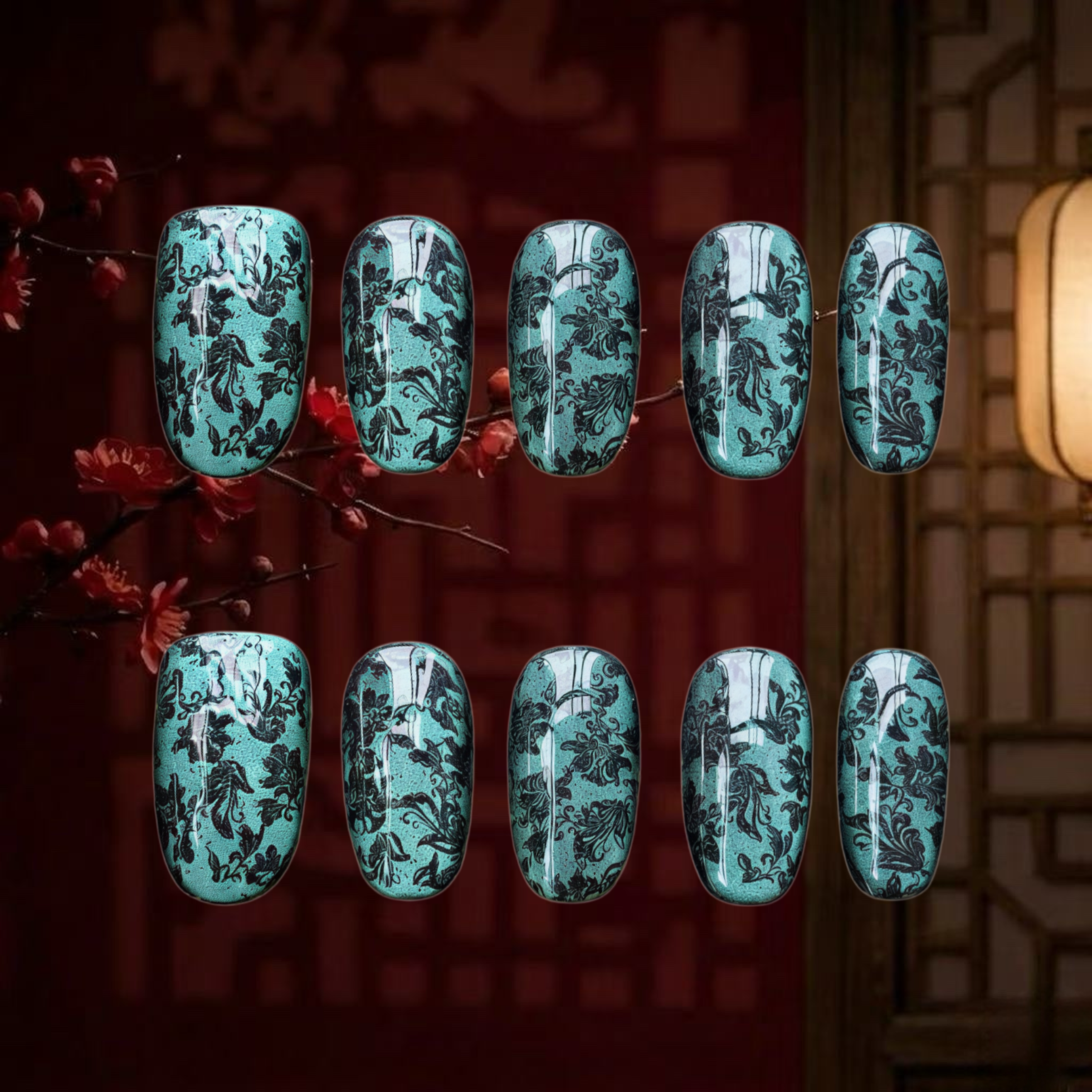 Turquoise nail art with black floral patterns on a dark background