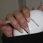 Close-up of a hand with decorative nails holding a white container labeled 'Crème Main'.