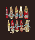 Decorative nail art designs with gemstones and pearls on a dark background